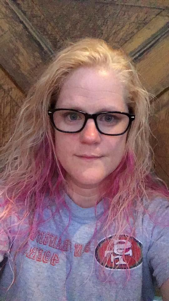 woman with pink hair and glasses taking a selfie