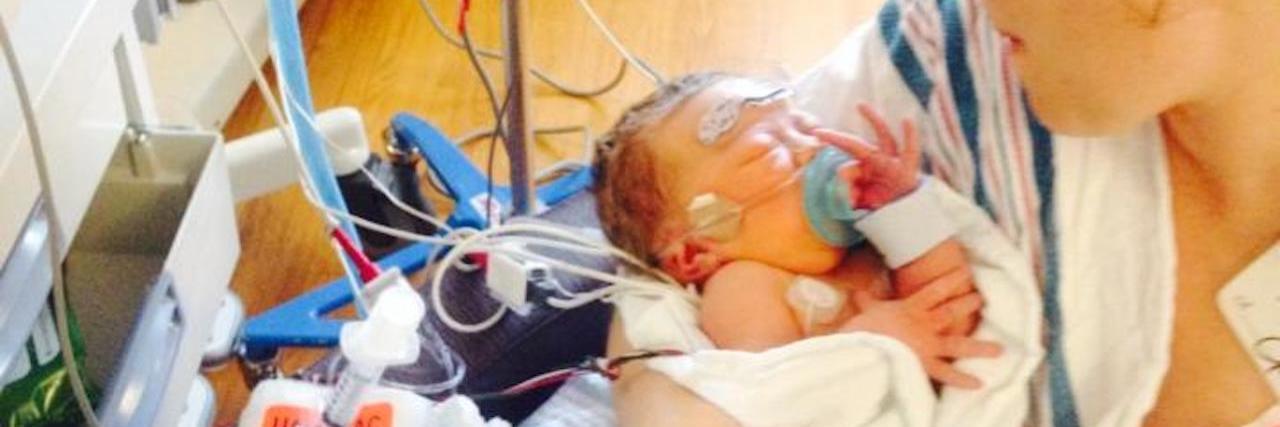 Dear Nurses, From the Moms Who Wouldn't Have Made it Without You Mother holding baby in NICU, baby has many wires