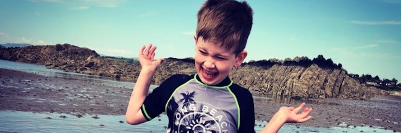 The 'Fakebooking' Days When Your Child Has a Disability Little boy full of joy standing in the middle of a lake