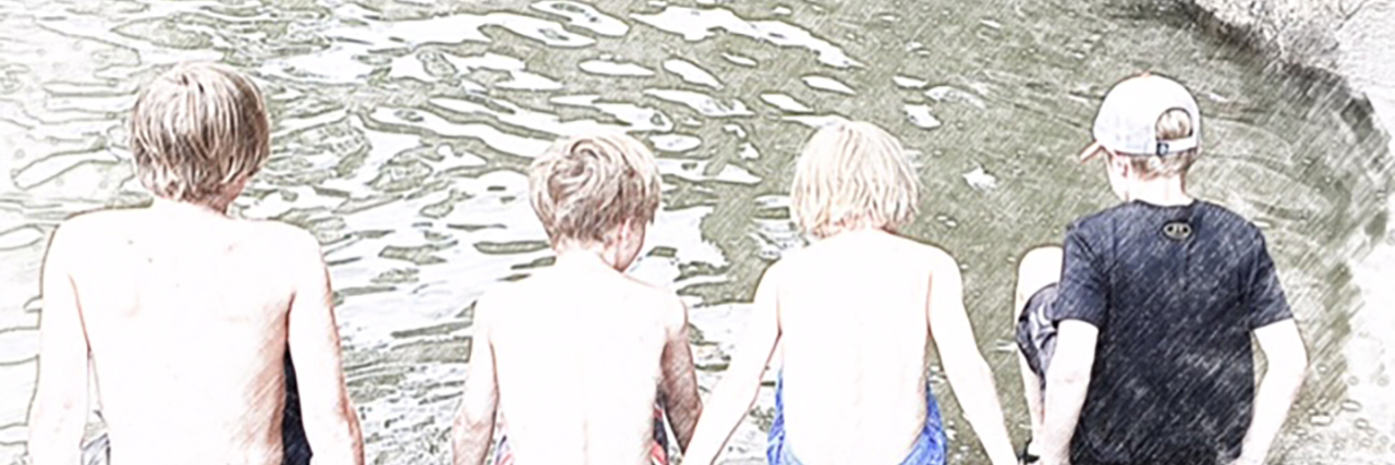 Boys sitting by a lake.