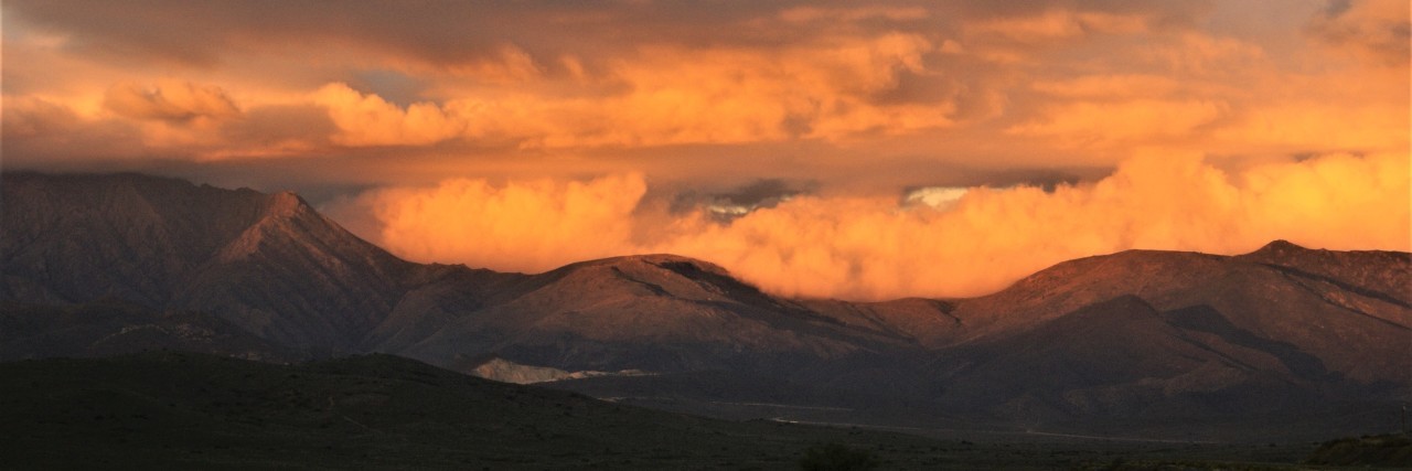 When Sick and Healthy People Live in 'Different Worlds' mountains covered by orange clouds at sunset