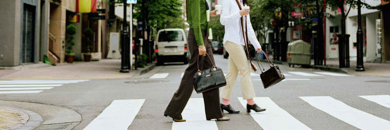 Two women crossing city street.