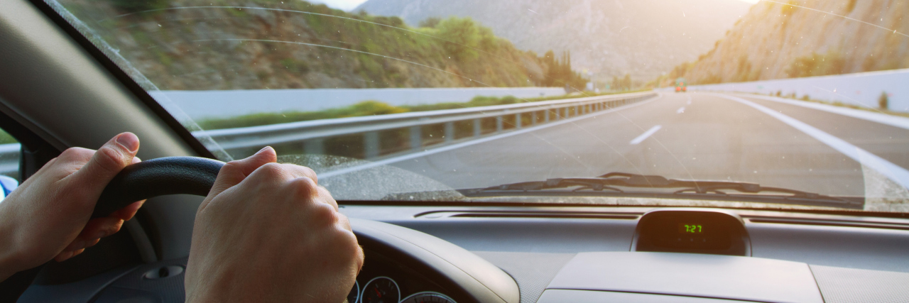 driving car on the mountain road, hands on steering wheel