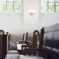 A picture of wooden pews in a church.