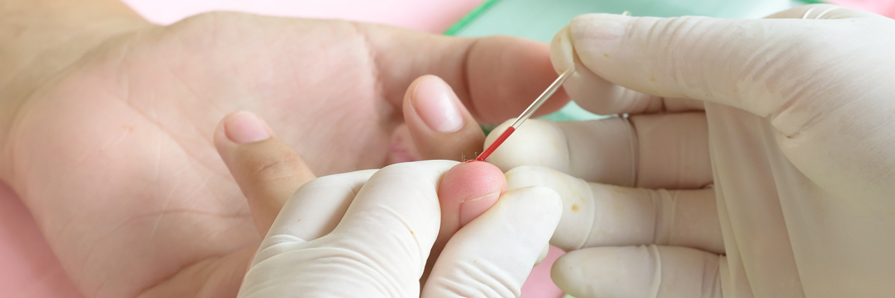 New painHS Blood Test Can Identify the 'Color' of Chronic Pain doctor taking blood from a patient's fingertip