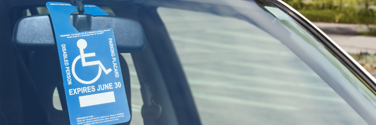 Using Disabled Parking With an Invisible Illness Disabled person parking placard in car window.