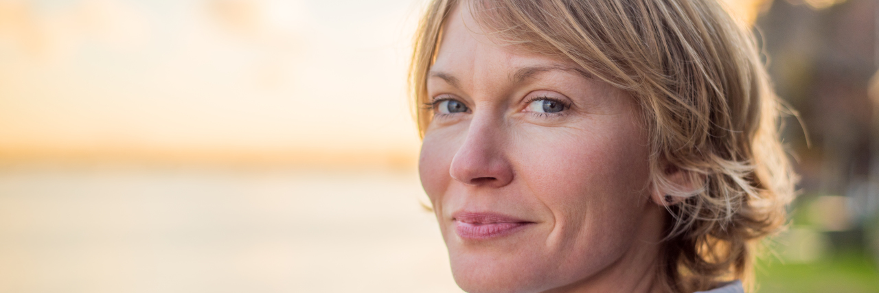 'You Will Find There Is Tremendous Magic in Cancer' Mid 30's Woman with strong smile at sunset.