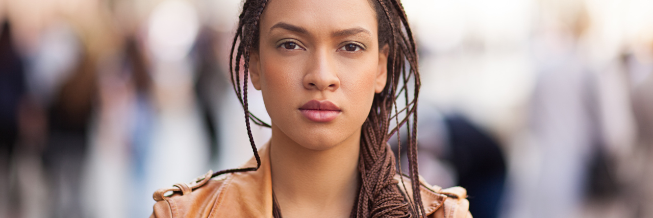 We Need to Stop Mistreating People With Lyme Disease woman wearing an orange jacket and staring ahead