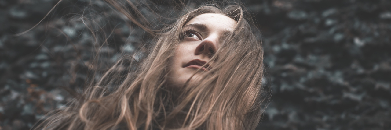 Why I Don't Approach My Multiple Chemical Sensitivity With Avoidance A camera looking up towards a woman's face, who is outside.