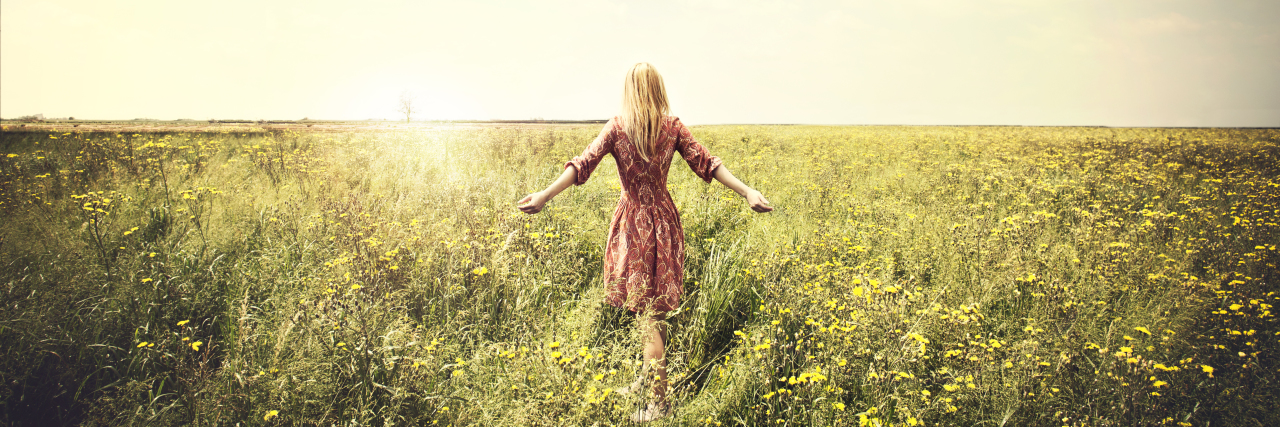 Being Naïve as an Aspie Adult Woman walking in nature towards the sun.