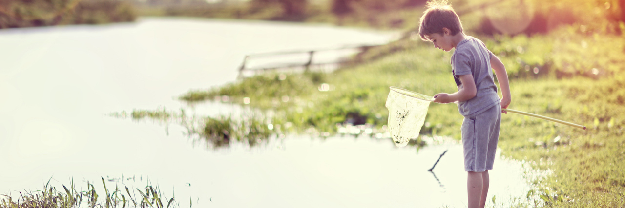 Male Rape Survivor Explains Dissociation A young boy at a pond, holding a fishing net.
