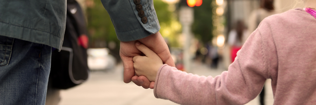 Estate Planning When You Have a Child With a Disability Father holding child's hand.
