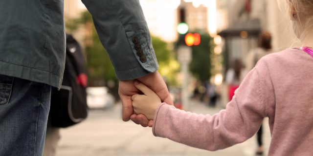 Estate Planning When You Have a Child With a Disability Father holding child's hand.