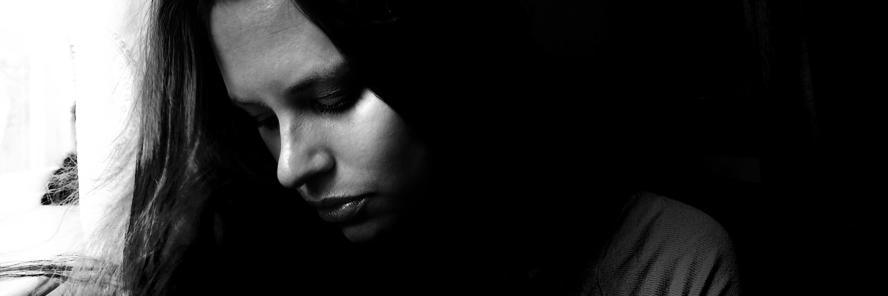 black and white portrait of young woman looking away in sadness and depression