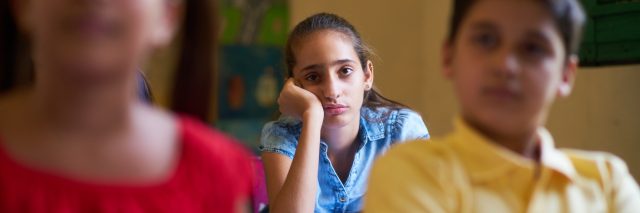 Young people and education. Group of hispanic students in class at school during lesson. Girl with anxiety, bored female student