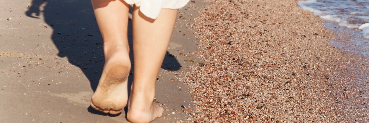 'What's That on Your Leg?' Life With Dermal Hemangiomas vacation travel - woman leg closeup walking on white sand relaxing in beach cover-up pareo beachwear.
