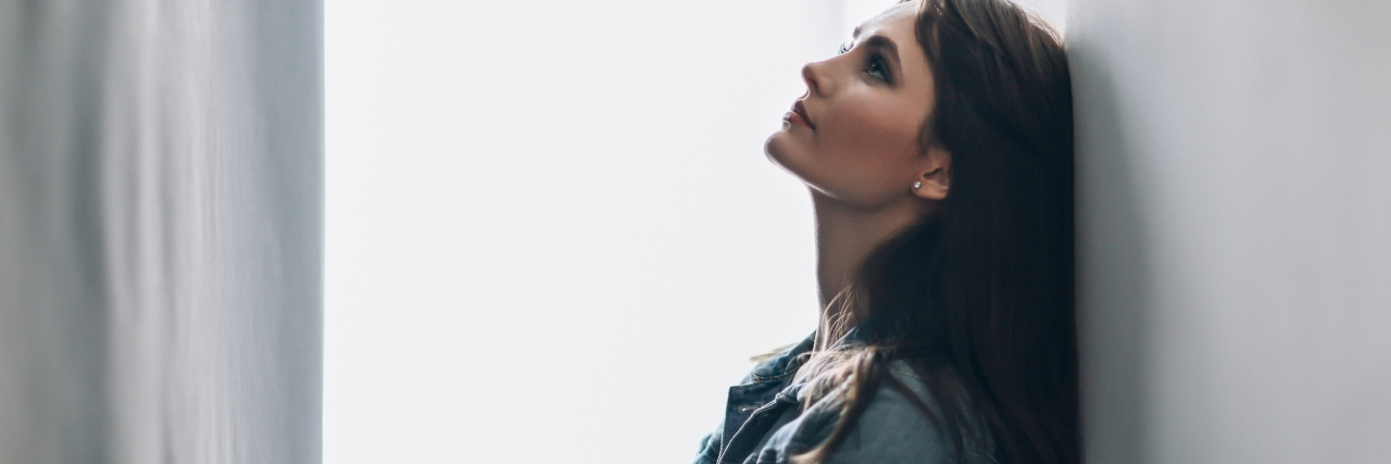 How Much Effort to Put Into Trying to Improve Your Health woman leaning against a wall and looking up