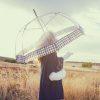 Woman carrying a solar umbrella in a field