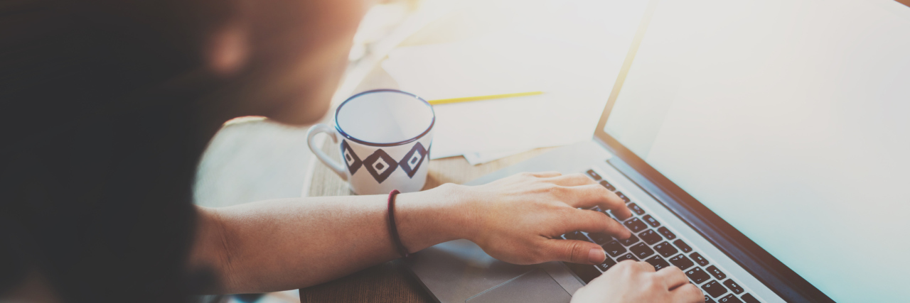 Why I Write About My Chronic Illnesses woman writing on her computer