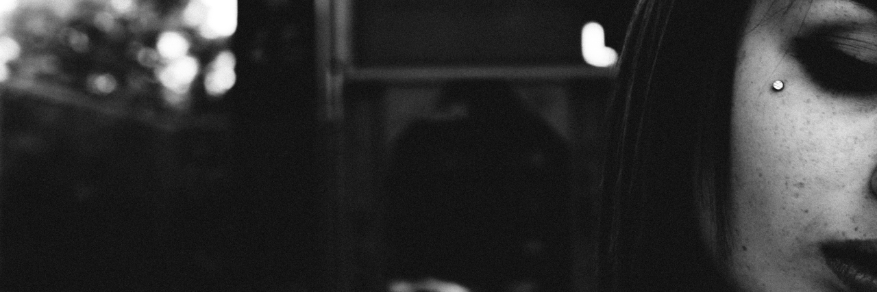 When You Tell Me 'I Don't Know How You Survive' A black and white image of a woman outside, only showing a small portion of her face.