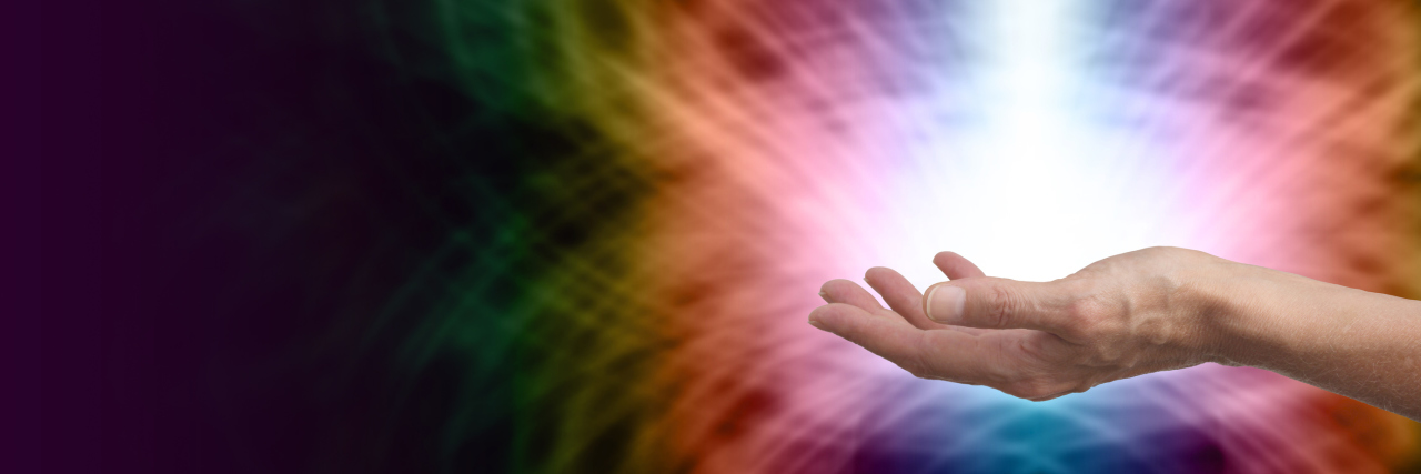 What Happened When I Saw a Shaman for My Chronic Illness healer holding out there hand, palm up, with colorful light beaming out around it