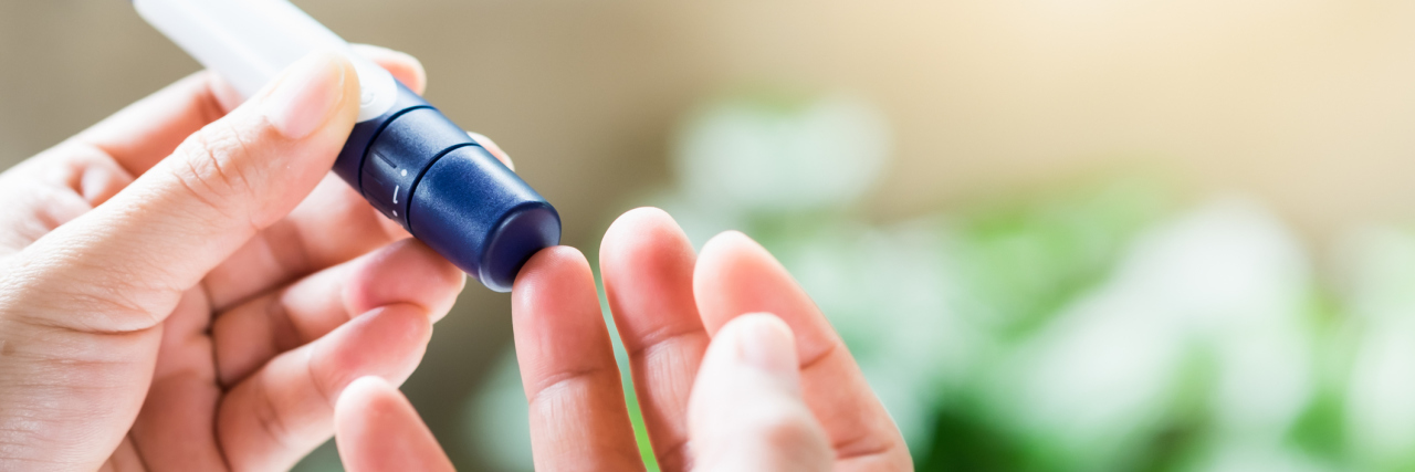 The Emotional Impact of Type 2 Diabetes woman pricking her finger to measure blood glucose levels