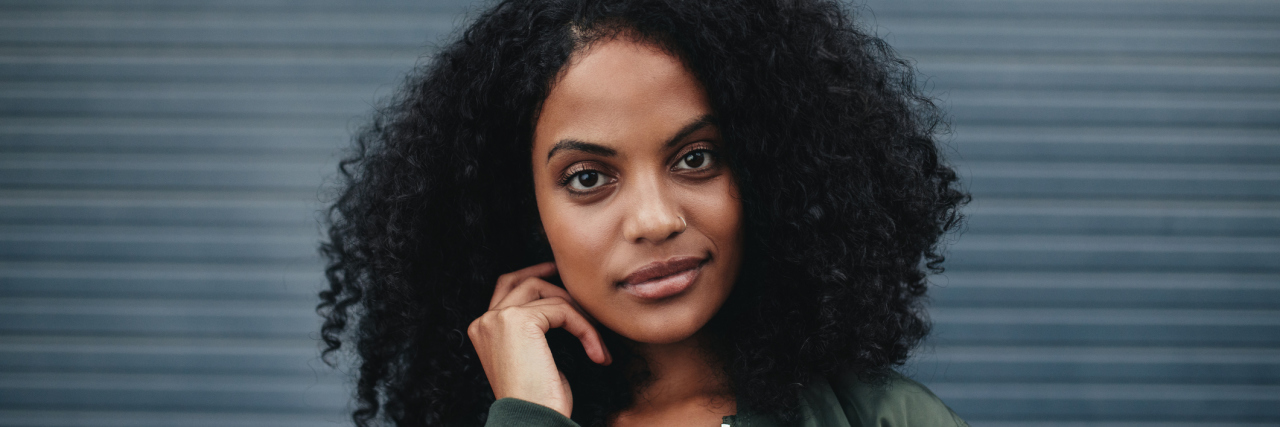 A picture of an African American woman giving a slight smirk towards the camera.