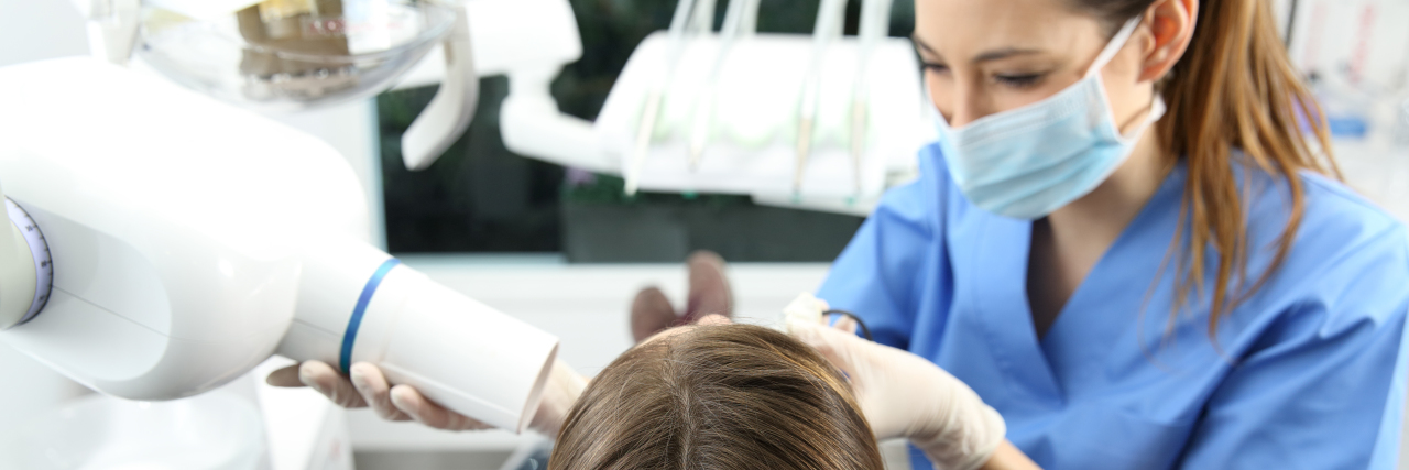 Tips for Visiting the Dentist When You Have Trigeminal Neuralgia Dentist taking x-ray of patient teeth in a clinic box with medical equipment in the background