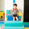 Portrait of a Hispanic boy having fun in a therapy room and going through and obstacle course in a children therapy center