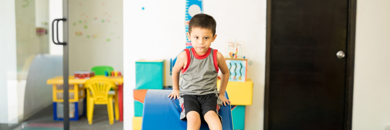 What You Need to Know About Early Intervention Portrait of a Hispanic boy having fun in a therapy room and going through and obstacle course in a children therapy center