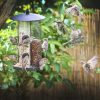 A picture of a bird feeder with sparrows eating from it, and flying around it.