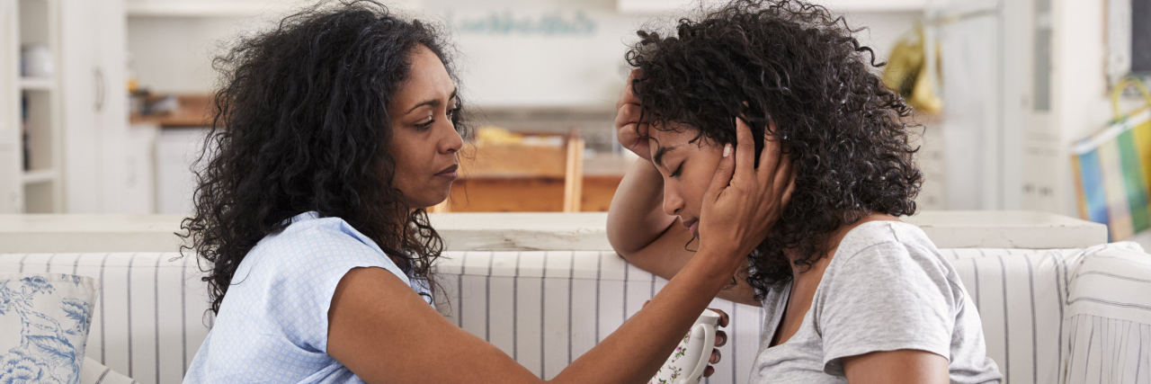 When My Chronic Pain Prevents Me From Being Present With My Children A mother talking to he teenager daughter on the couch.