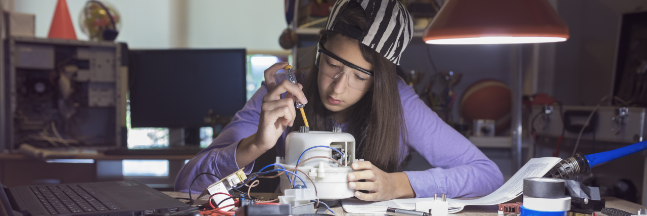 Teenage girl deeply focused on an engineering project