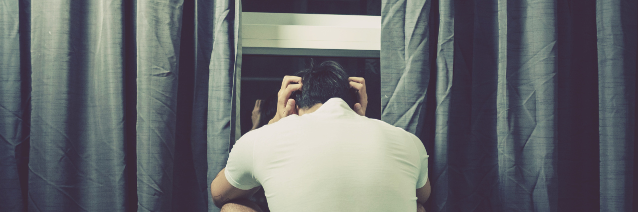 Spending a Night With the 'Painsomnia' of Erythromelalgia man sitting on bed, head in hands at night