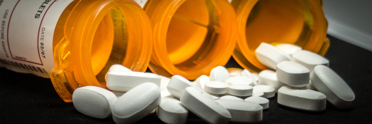 Taking Medications for Long QT Syndrome and Solar Urticaria prescription bottles with white pills spilling out