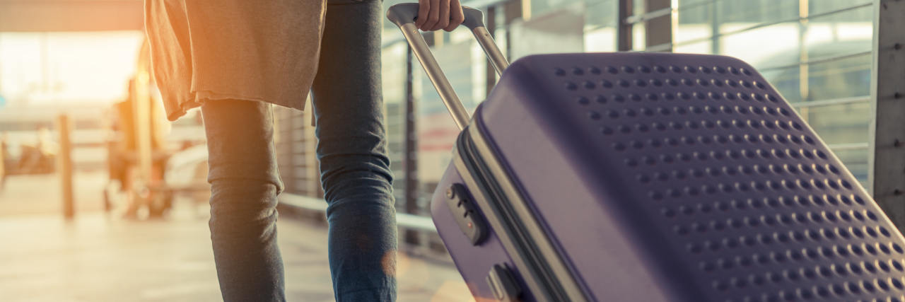 woman walking in the airport with a suitcase