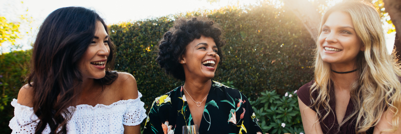 What Happened When I Asked My Friends About Their Mental Health Needs A group of friends laughing and sitting outside