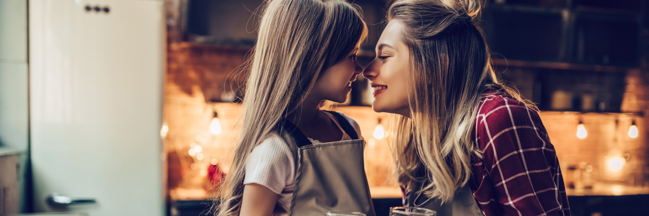 How My Eating Disorder Past Is Helping Me Raise My Children Attractive young woman with her little cute daughter are cooking on kitchen. Drinking milk, eating cakes and cookies.