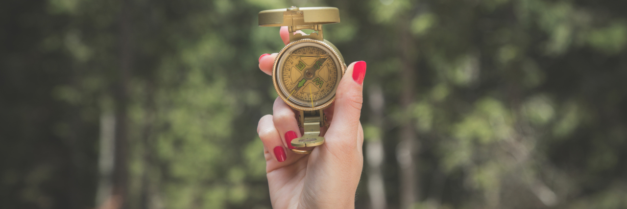 The Messy Intersection of Chronic Pain and Mental Health A photo of a woman holding a compass.