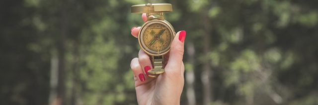 A photo of a woman holding a compass.