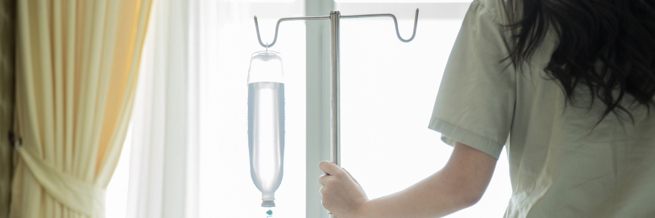 6 Tips for Infusion Day A patient walking with an IV bag and pole.