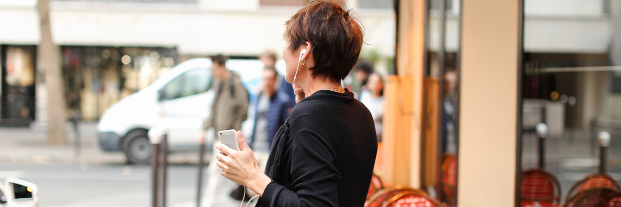 Why I Sing and Dance Through My Fibromyalgia Pain An older woman listening to an iPod, dancing outside.