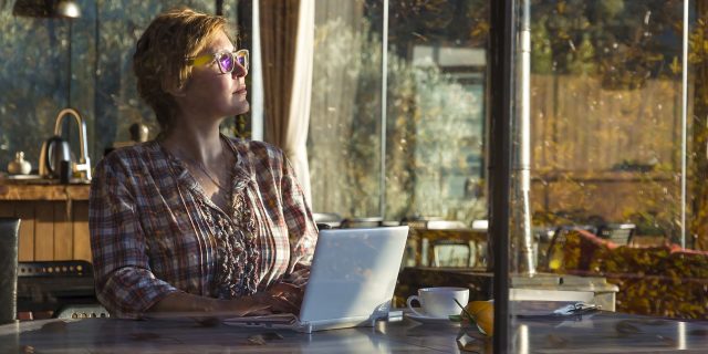 When You Ask 'Why Me?' About Your Chronic Illness A picture of a woman sitting inside, on her computer.