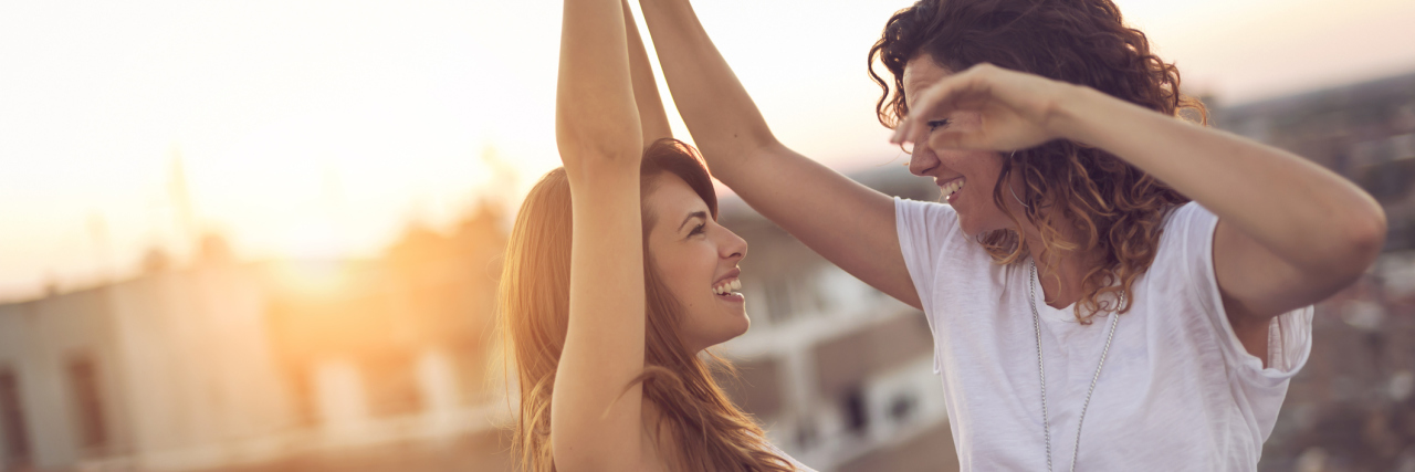 What It's Like to Date Someone With Bipolar or Borderline two women lesbians dancing on rooftop happy
