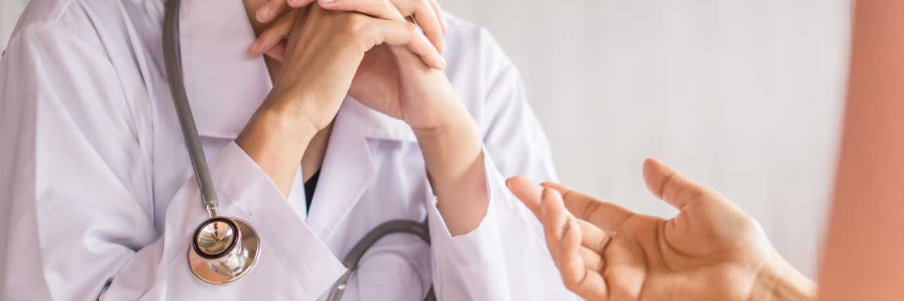 female doctor with hands crossed listening to patient