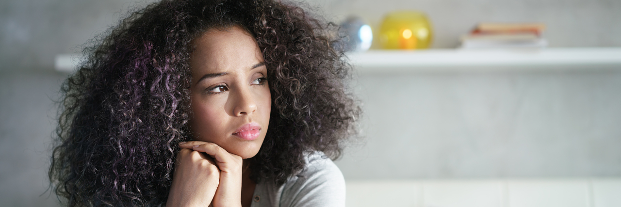 How My Tragedy Built Me a Community Lonely young latina woman sitting on bed