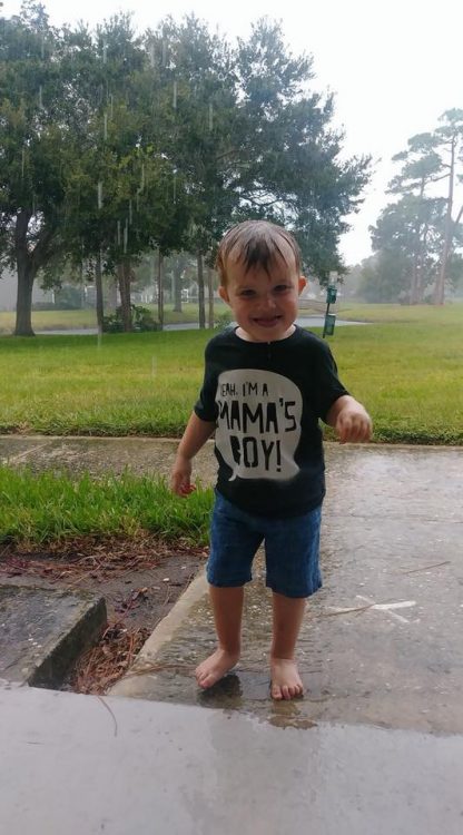 Little boy with wet clothes smiling at camera