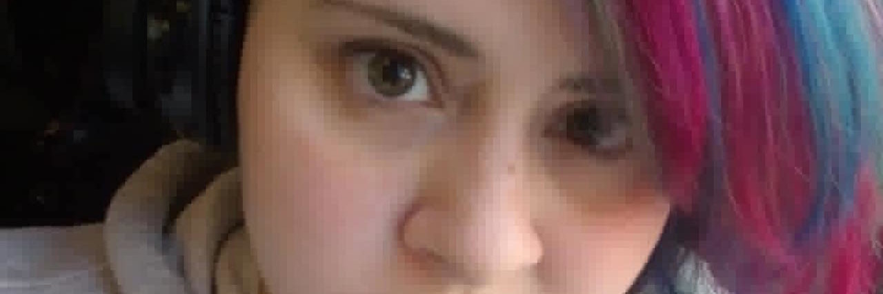 How to Love Someone with Fibromyalgia and Arthritis woman taking a selfie wearing a gray sweatshirt with magenta and blue hair