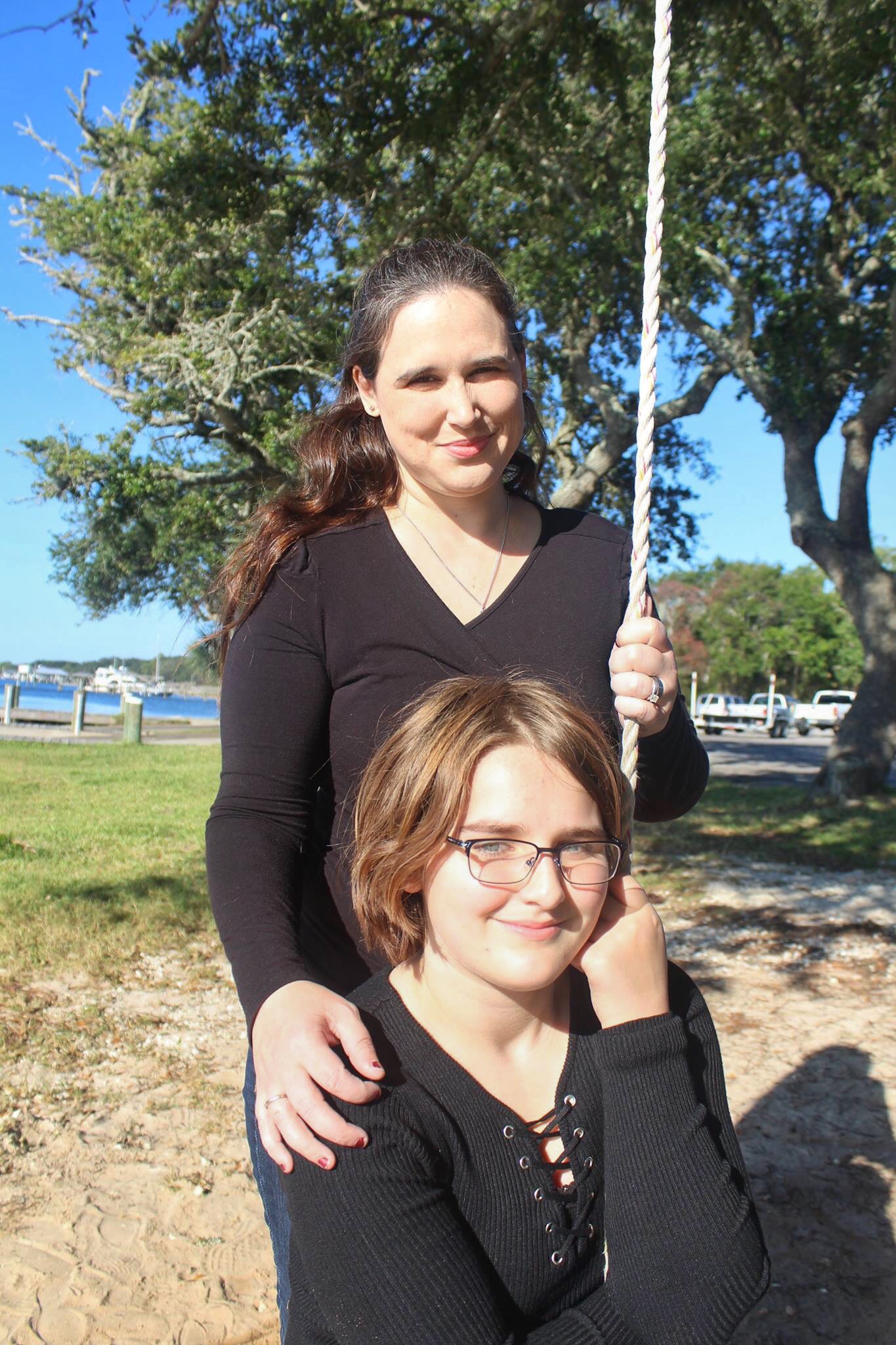 photo of woman and daughter sitting in sunlight and smiling