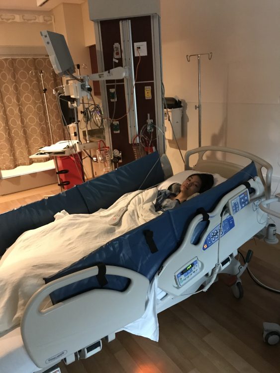 woman lying in hospital bed covered with blanket